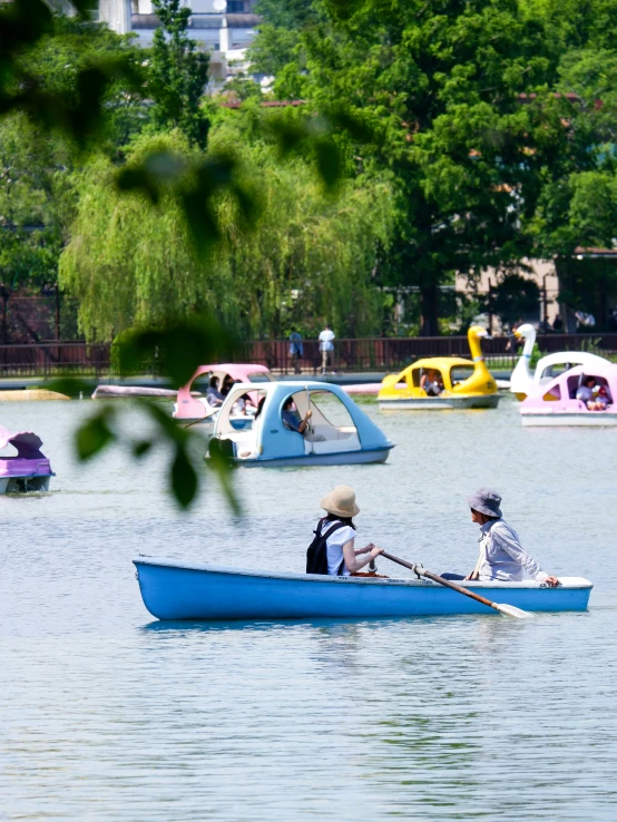 people paddle their boats in the calm lake