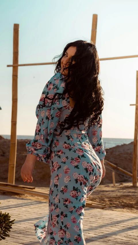 a woman in floral dress with the ocean in the background