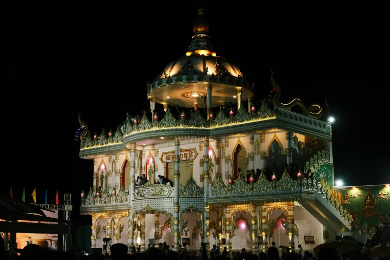 a lit building at night with people in it