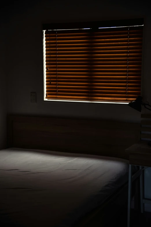 the room has a bed in it with its side turned towards the dark