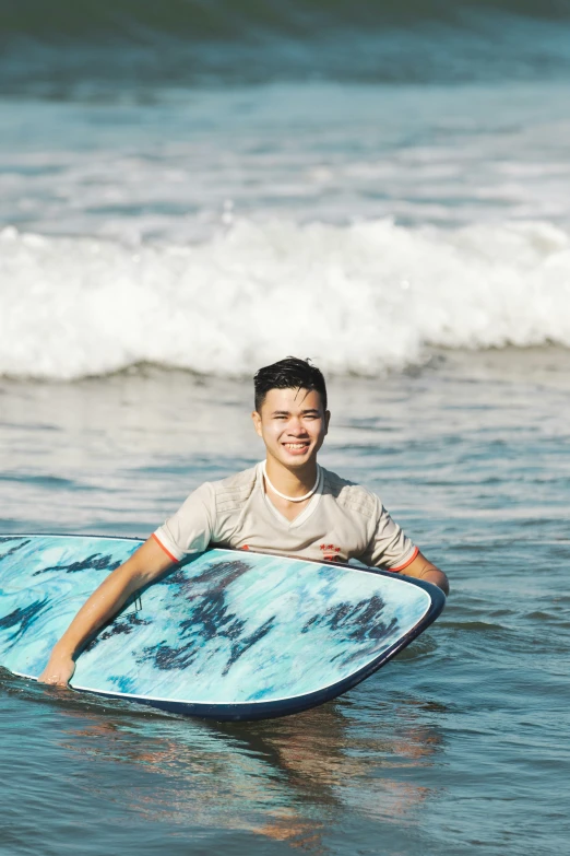 a young man on a surfboard smiling at the camera