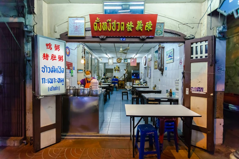 a street side with tables, chairs and a red sign