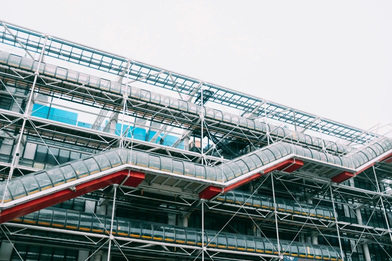 scaffolding around a building with a very large pipe system in front