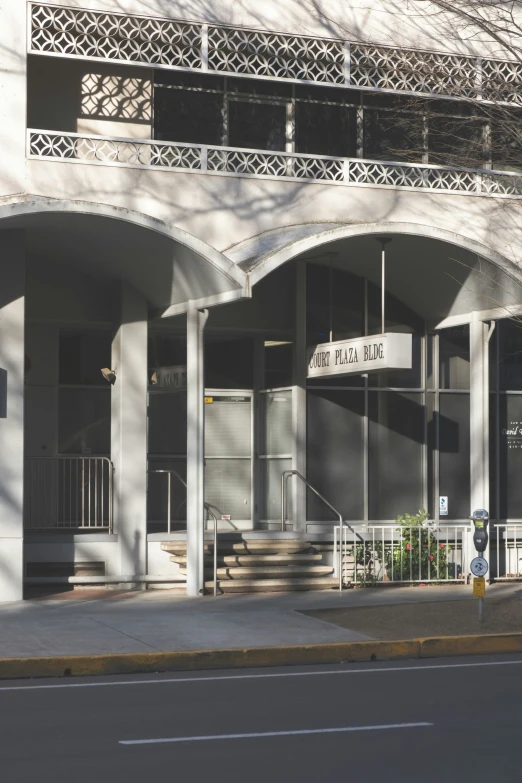 a group of arches and doors hang from a tall building