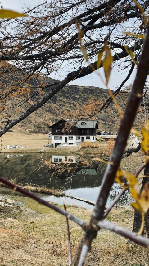 a white house surrounded by trees near water