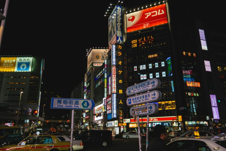 a busy street with neon signs and a large building