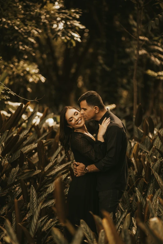 the couple pose for a po in a field of crops