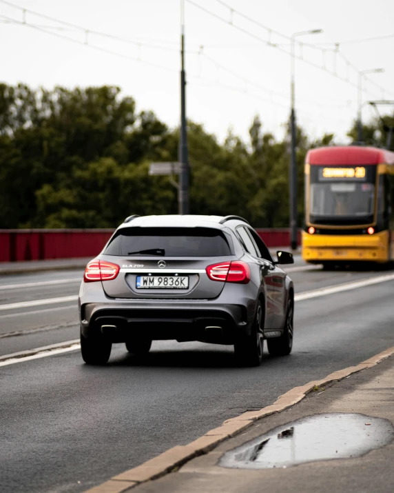 car stopped at a light on the road beside a bus