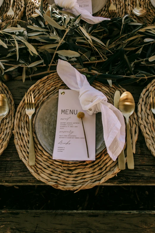 a table with place setting on it has flowers in baskets