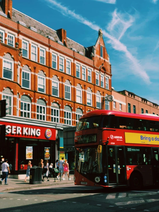 a double decker bus in front of a large red brick building
