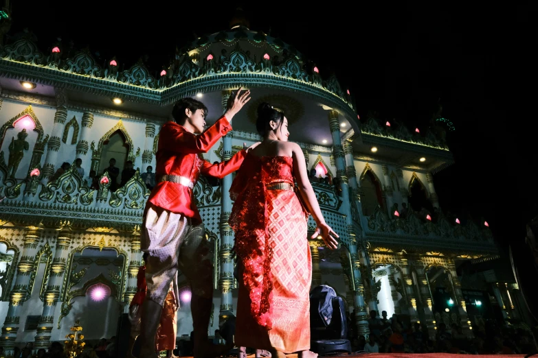 two people dressed in red standing outside of a building