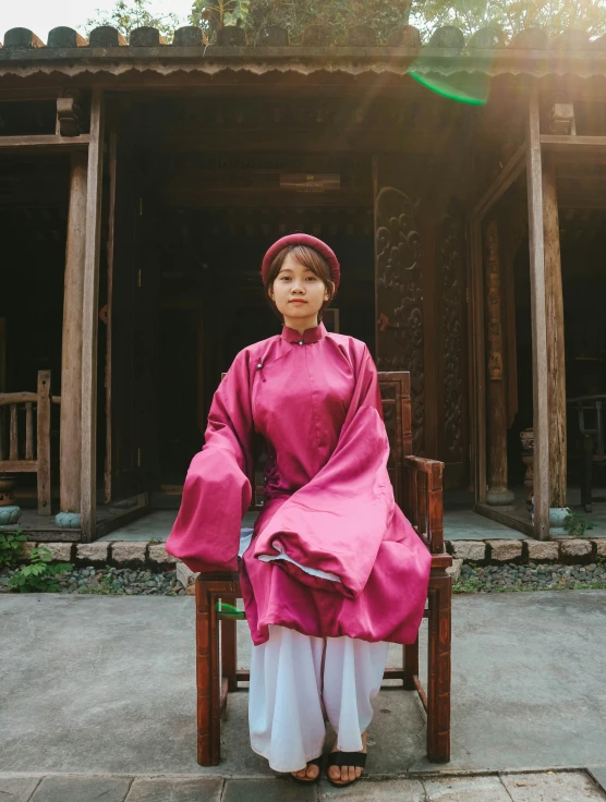 a woman sitting in a chair outside a chinese building