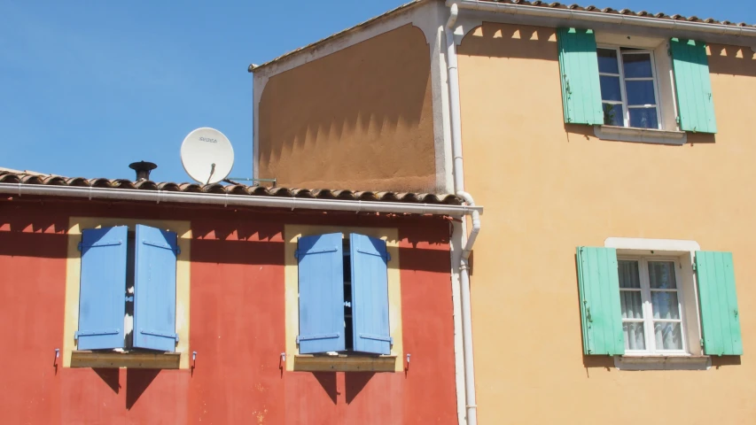 a building that has windows with green shutters