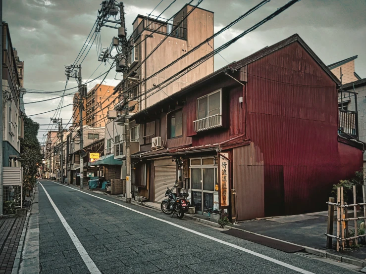 there is a red building and bikes in the alley