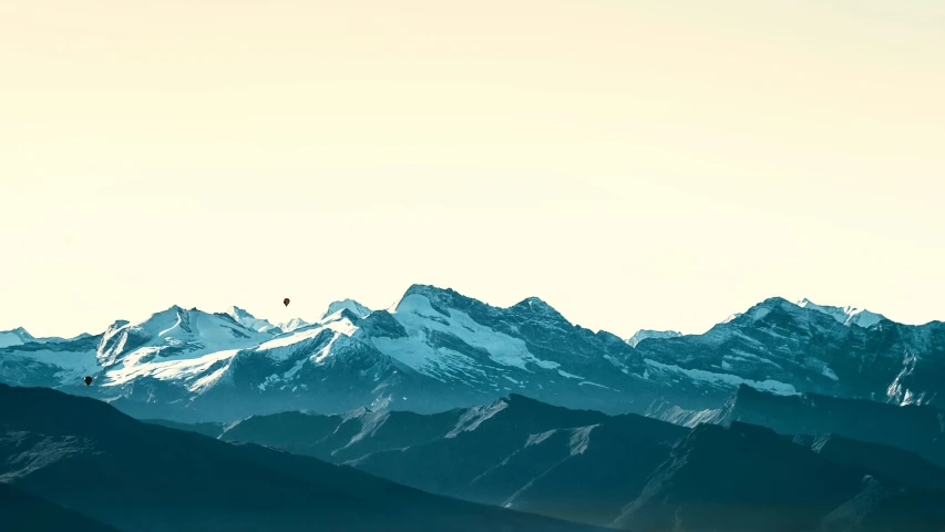 a large mountain covered in snow and some birds