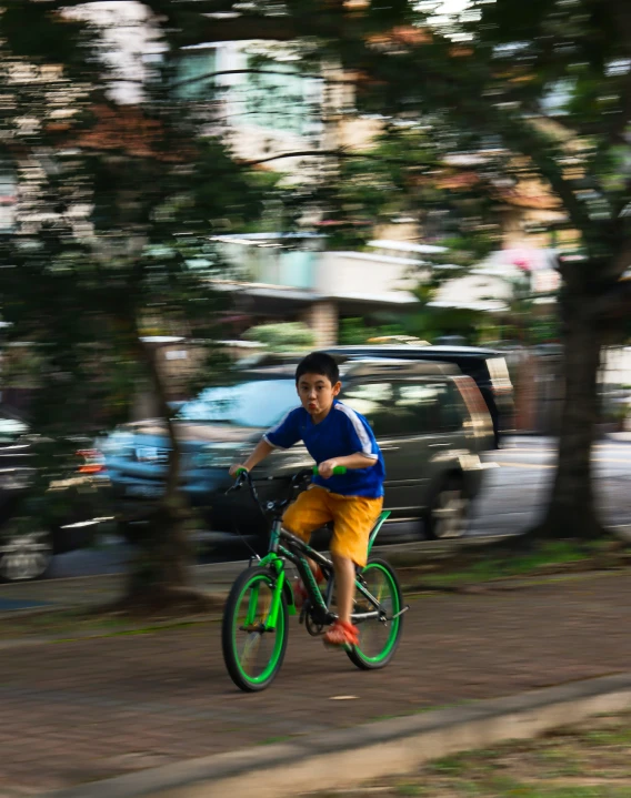 the  is riding his bike down the street