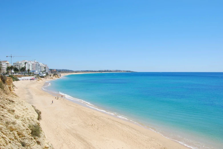 some blue water and buildings on a beach