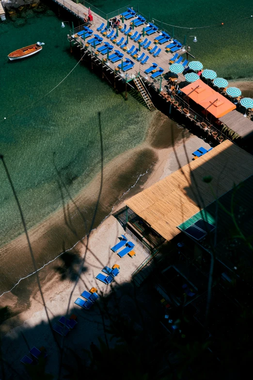 an overhead view of a beach with blue umbrellas