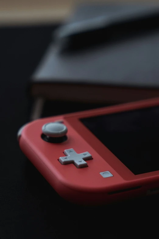 a red nintendo wii game controller on a table