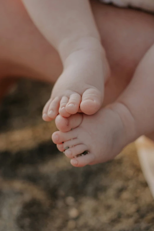 the legs of a baby being held by it's mother