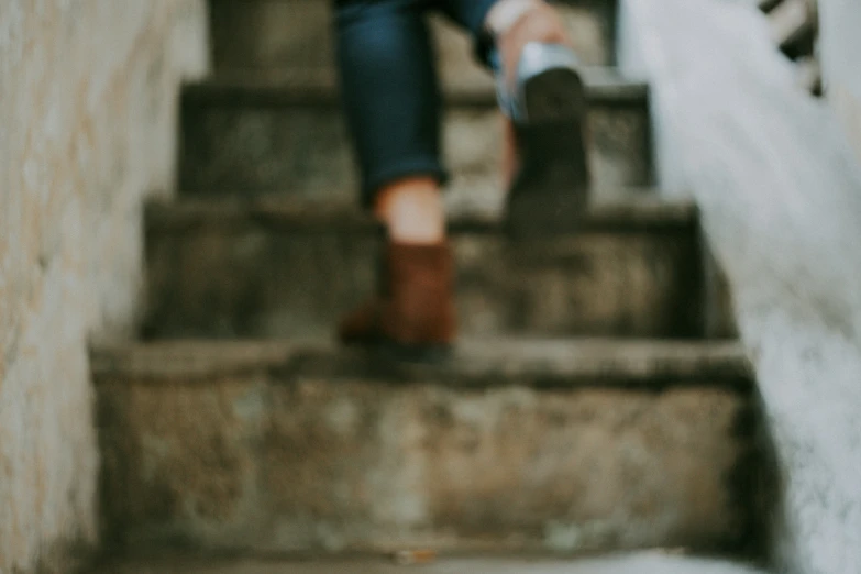 a woman sitting on top of stairs while holding a skateboard