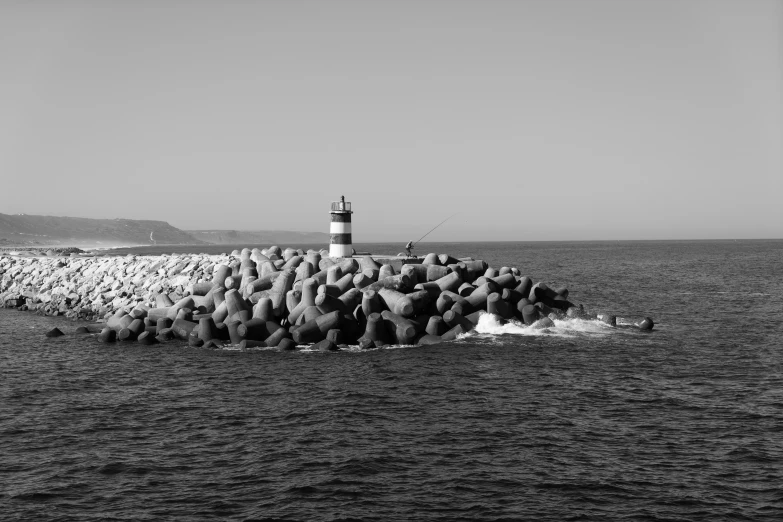 there is a lighthouse on a rock island in the ocean