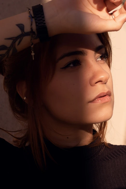 a woman poses with her hand on her head