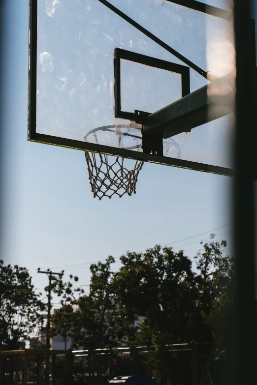 an empty basketball hoop hanging above a field