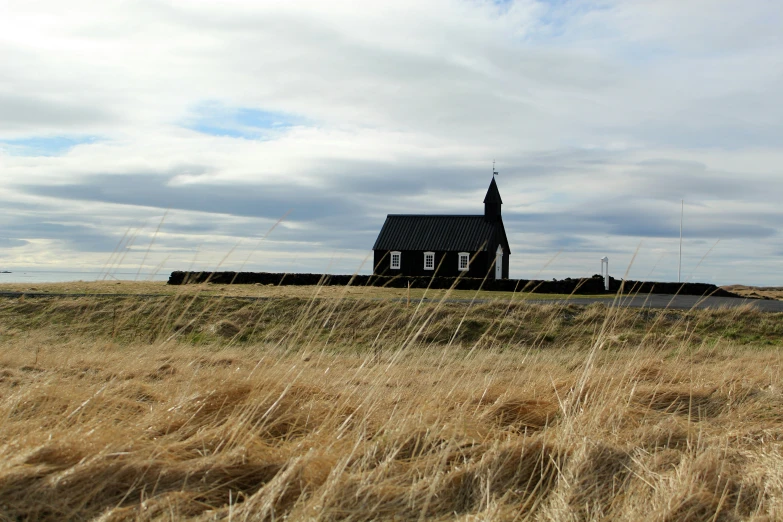 an old church is in the middle of a field