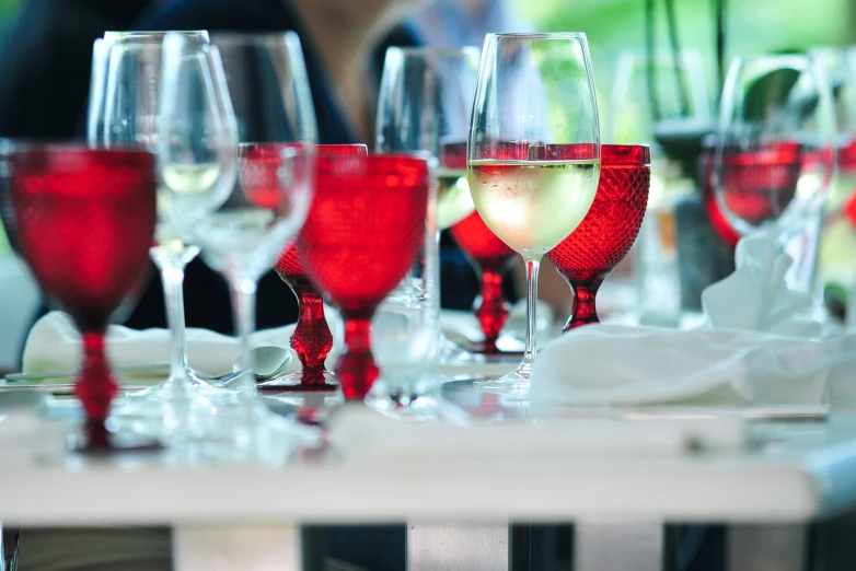 a line of wine glasses filled with red and white wines