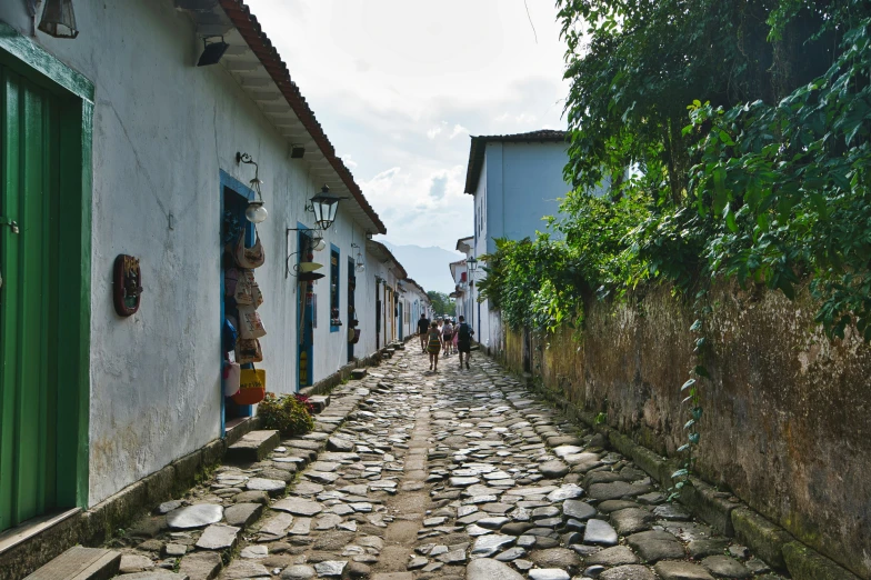 people are walking in a cobble stone street