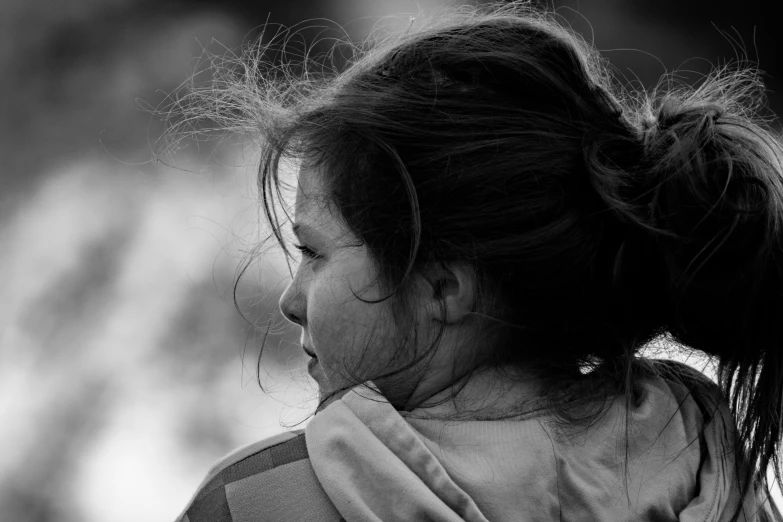 the back of a child's head and shoulders are in black and white