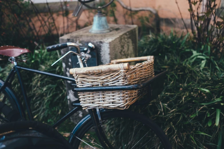 a close up of a bike with a basket in front of a brick wall