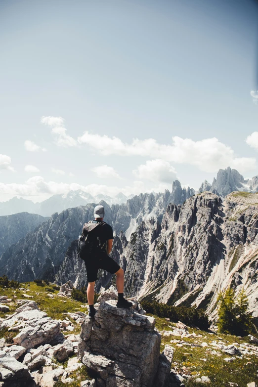 a man with a backpack sitting on top of a rock