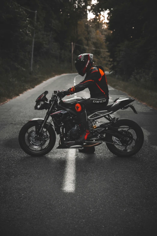 the motorcyclist is wearing a red and black leather outfit