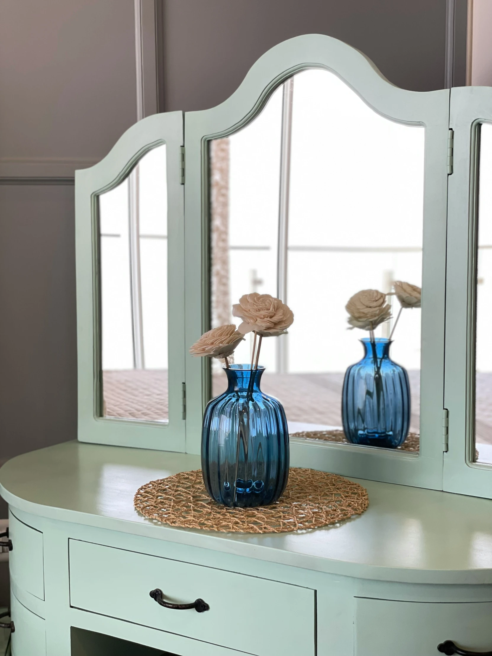 vases sitting on top of a table next to two mirrors