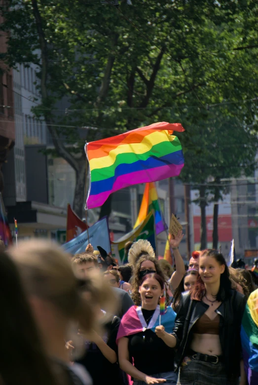 several women standing in the street with rainbow flags