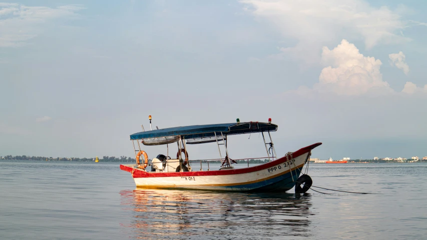 a small boat with a cover on it's front end in water