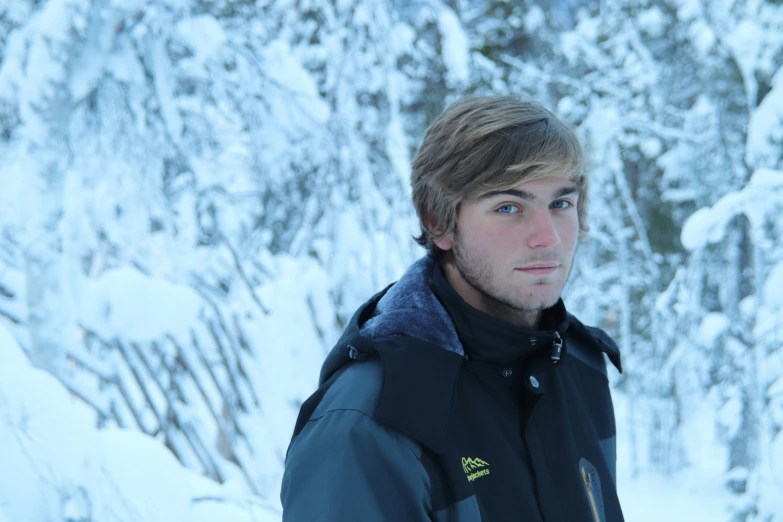 a man stands in front of a snowy mountain