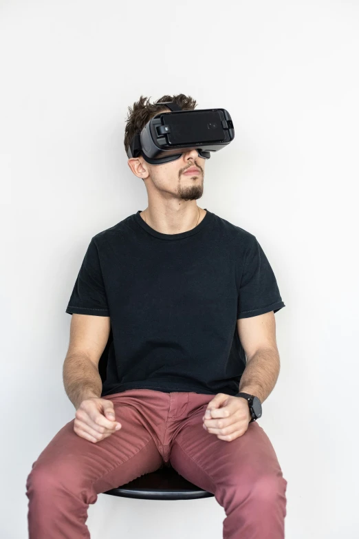 a man sitting on top of a chair with a virtual glasses