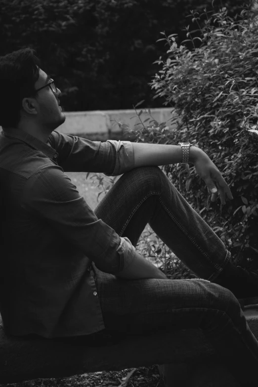 a young man sitting on a bench in the sun