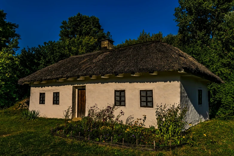 a small old house with some trees in the background