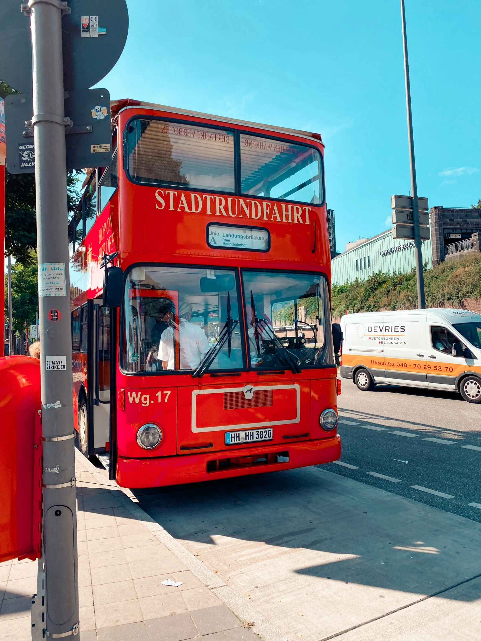 the red double decker bus is driving down the street