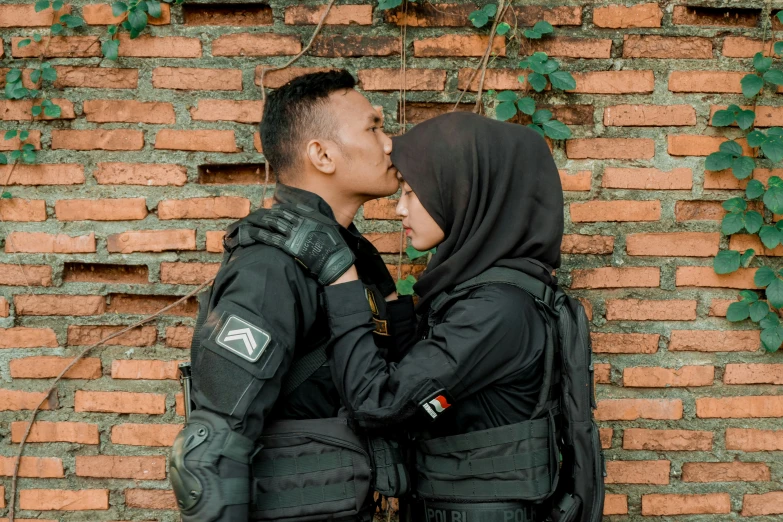 two people standing by a wall looking at each other