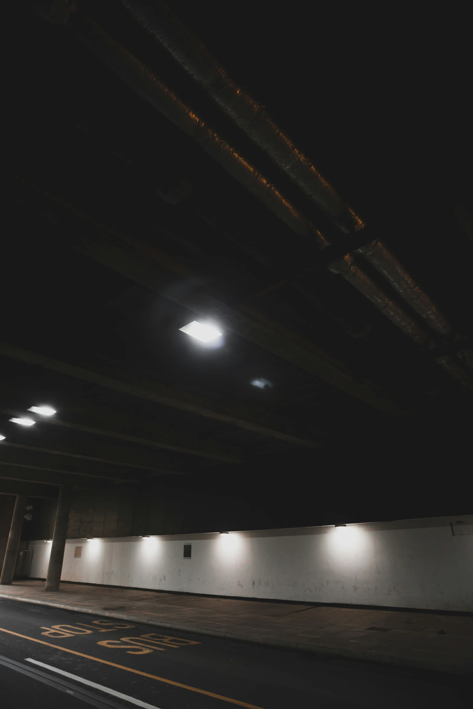 an empty street under an overpass at night