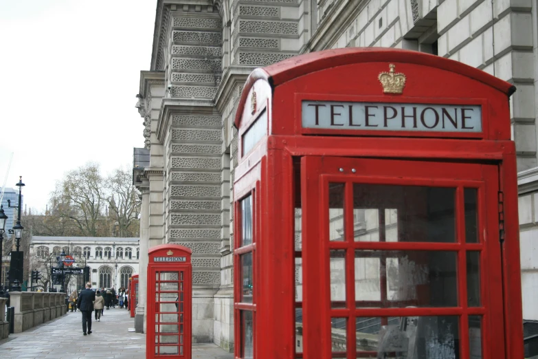 an old red phone booth in the middle of the road