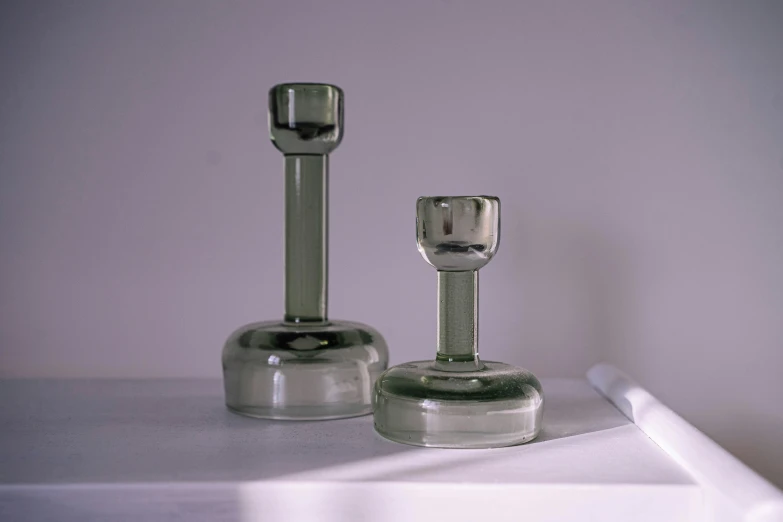 three glass objects are lined up on the table