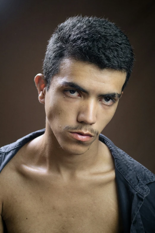 young man with small hair and moustache looking ahead