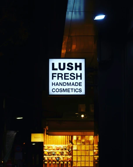 a sign reading lush fresh handmade cosmetics in front of a building