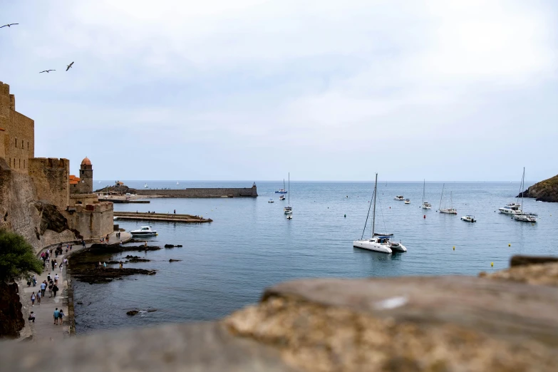 a harbor filled with lots of boats next to some stone buildings